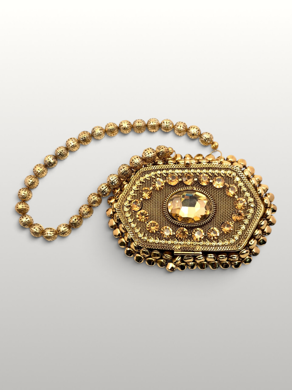 ThreadItStudio Maharani metal batua bag with gold evil eye motif and beaded handle on white background