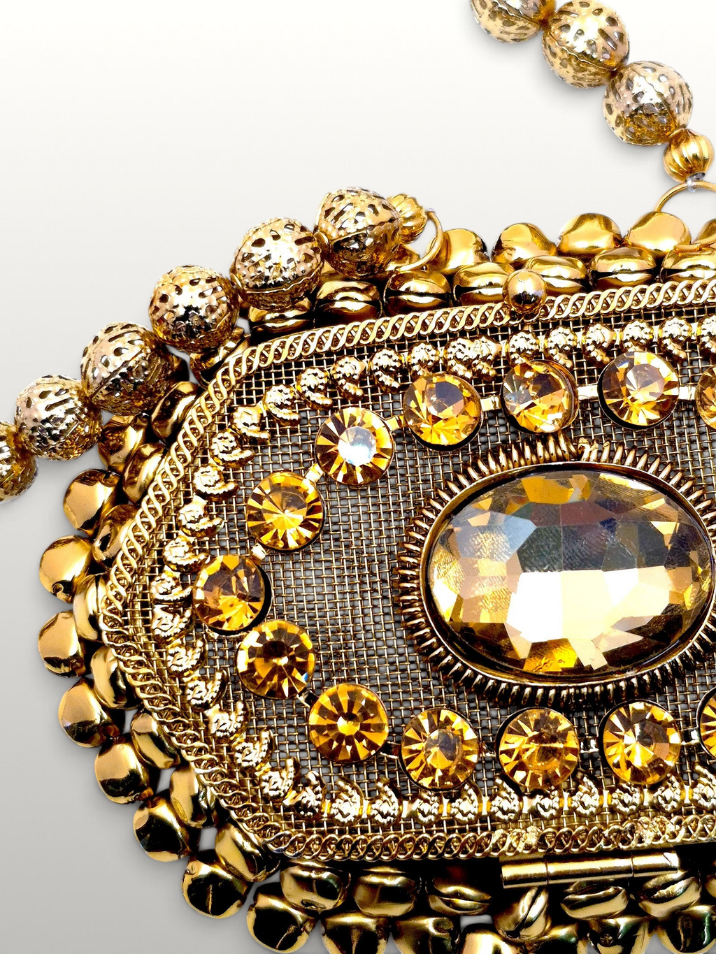 ThreadItStudio Maharani metal batua bag featuring a golden evil eye motif with intricate stone and bead detailing.