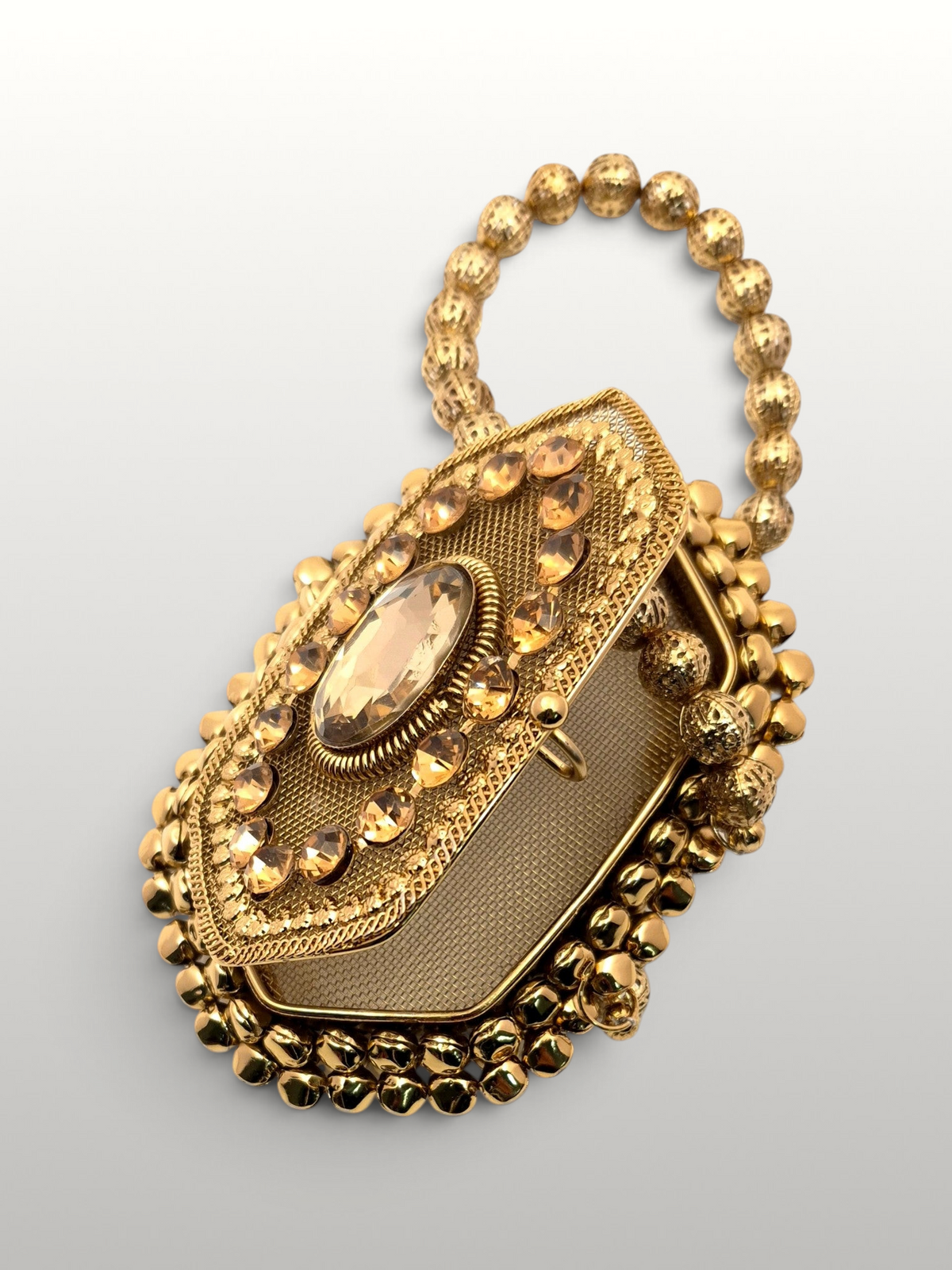 ThreadItStudio Maharani metal batua bag with gold evil eye motif, crystal embellishments, and a beaded handle.