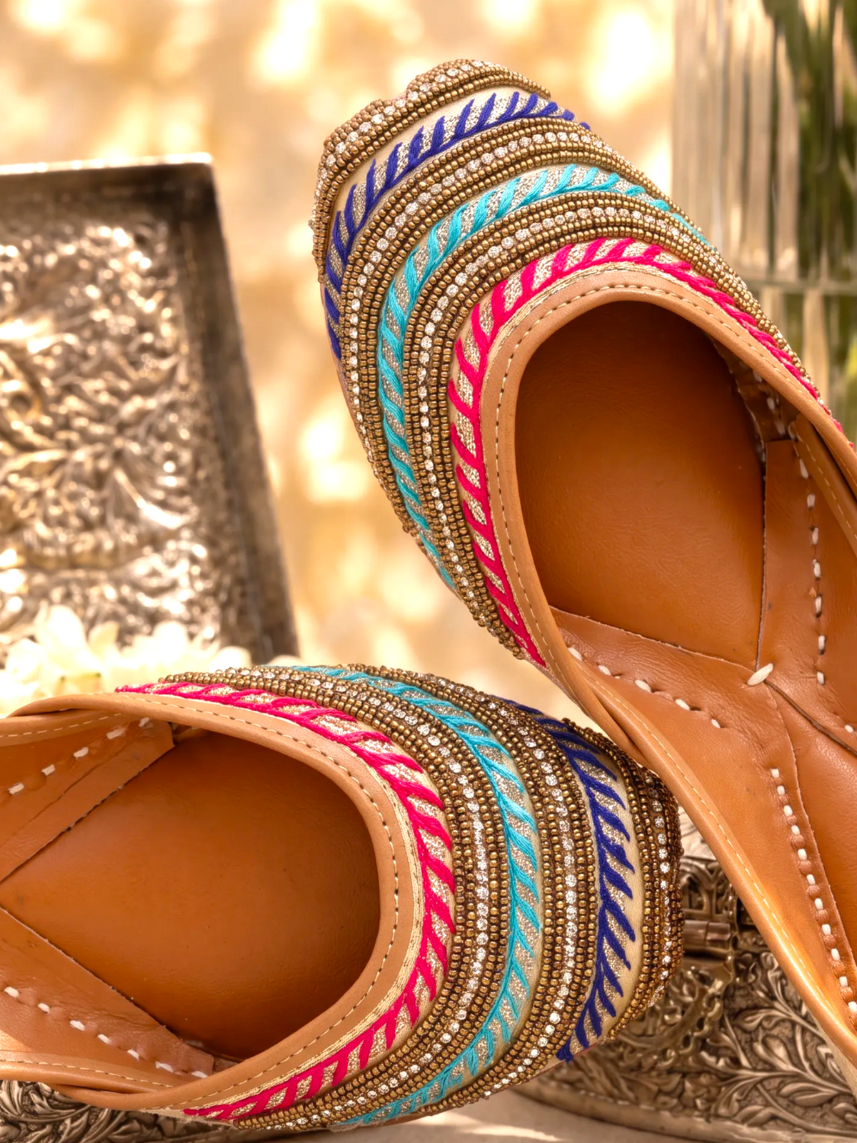 ThreadItStudio multi-color Punjabi juttis with intricate hand-embroidered dabka work worn with matching teal trousers.