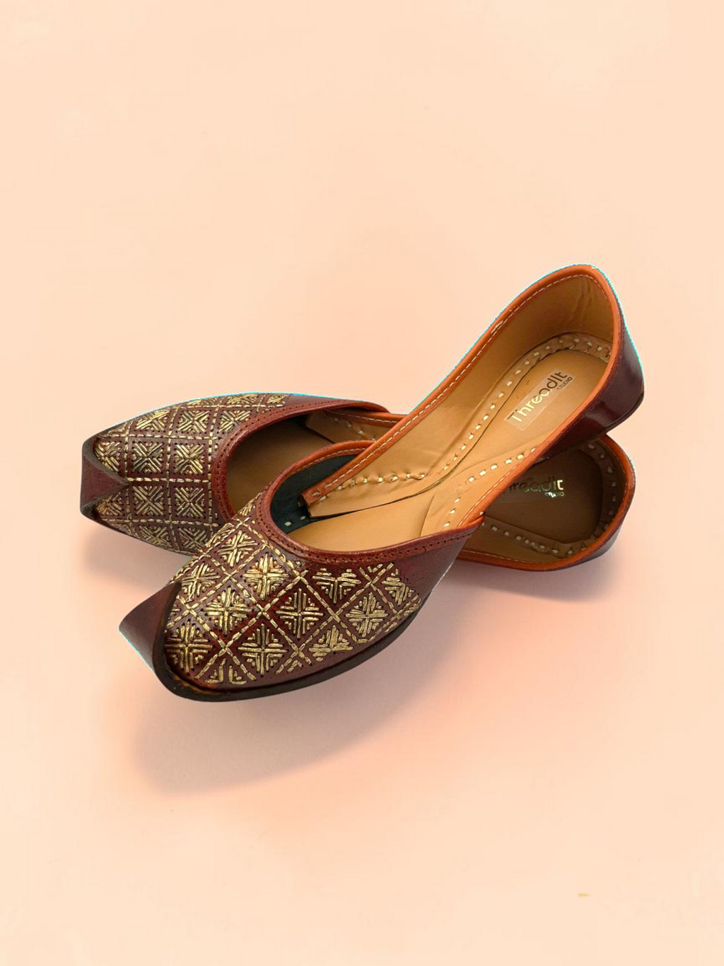 ThreadItStudio brown leather juttis with gold-thread grid embroidery and traditional curved toe design.