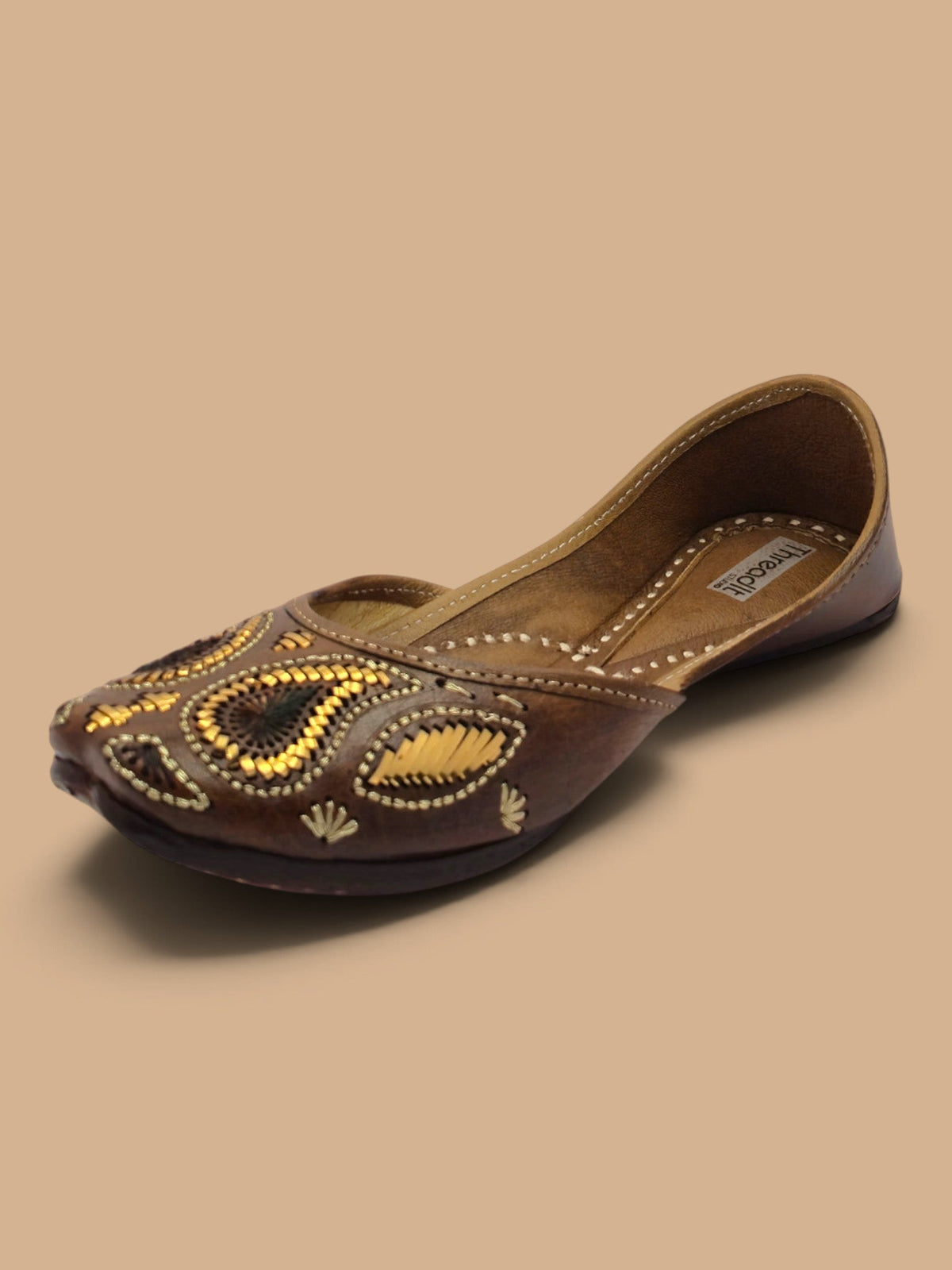 ThreadItStudio Ambi Phulkari juttis in brown leather with intricate gold paisley embroidery and hand-stitched details.