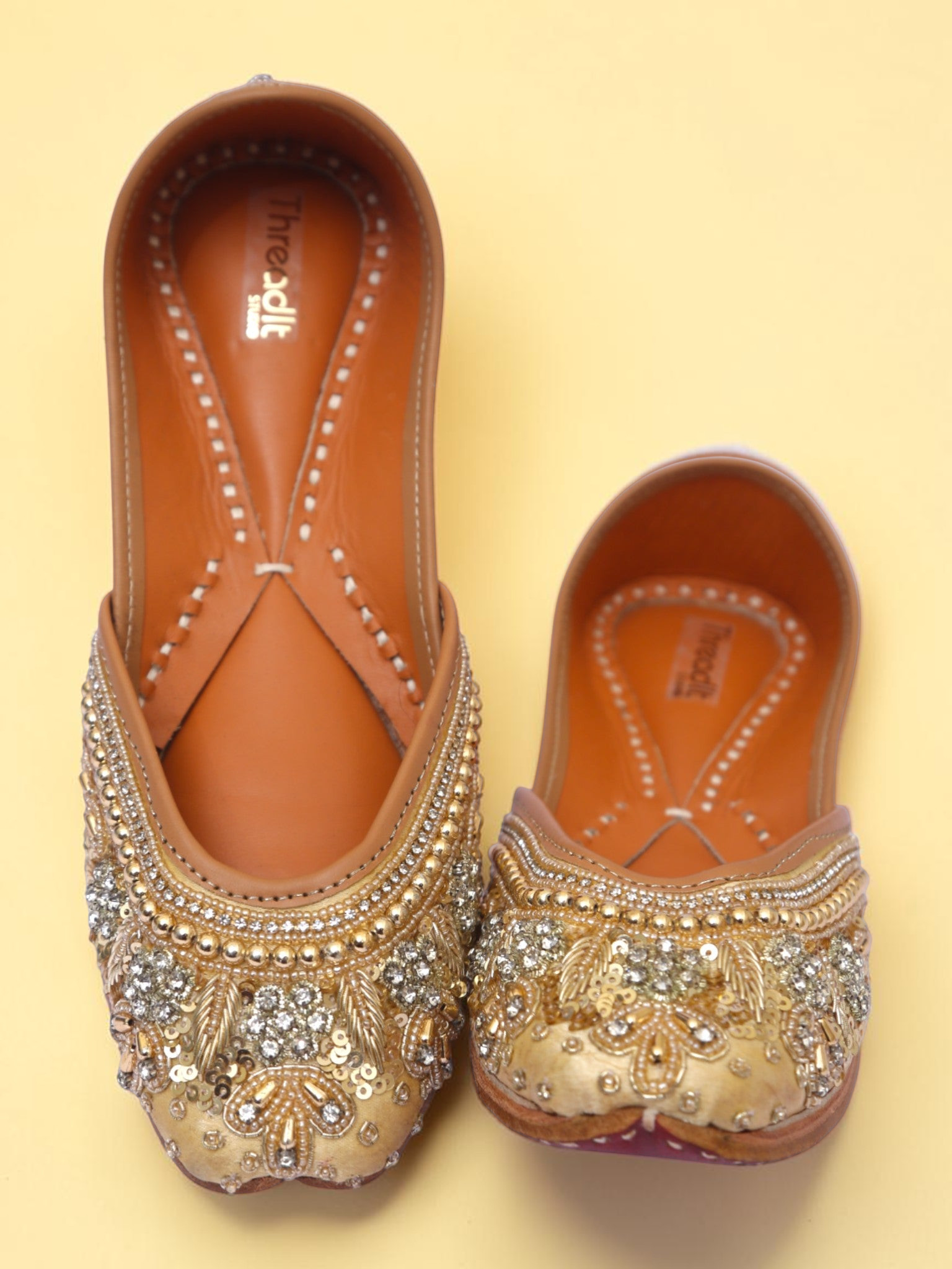 ThreadItStudio golden jutti featuring intricate pearl and sequin embroidery on a traditional handcrafted flat shoe