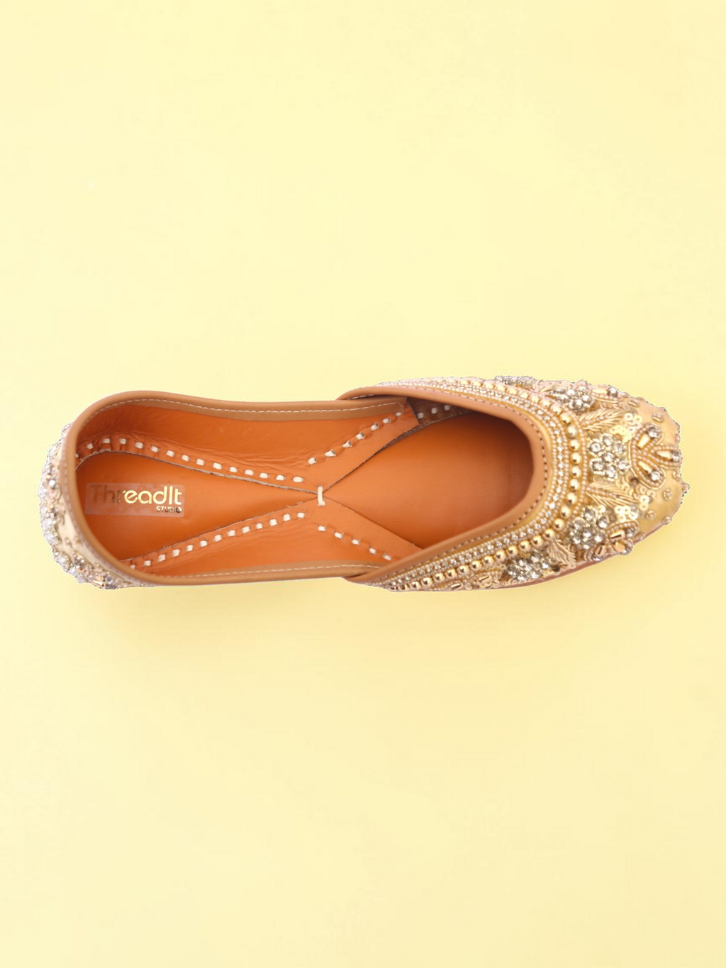 ThreadItStudio golden jutti with intricate pearl and bead embroidery on a soft yellow background