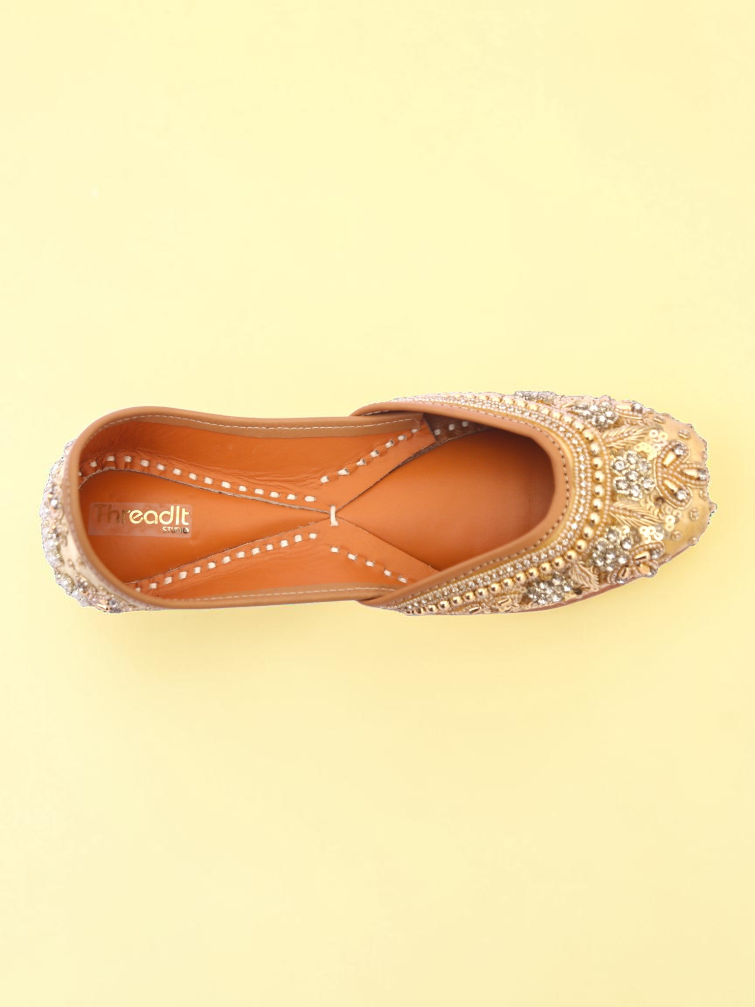 ThreadItStudio golden jutti with intricate pearl and bead embroidery on a soft yellow background