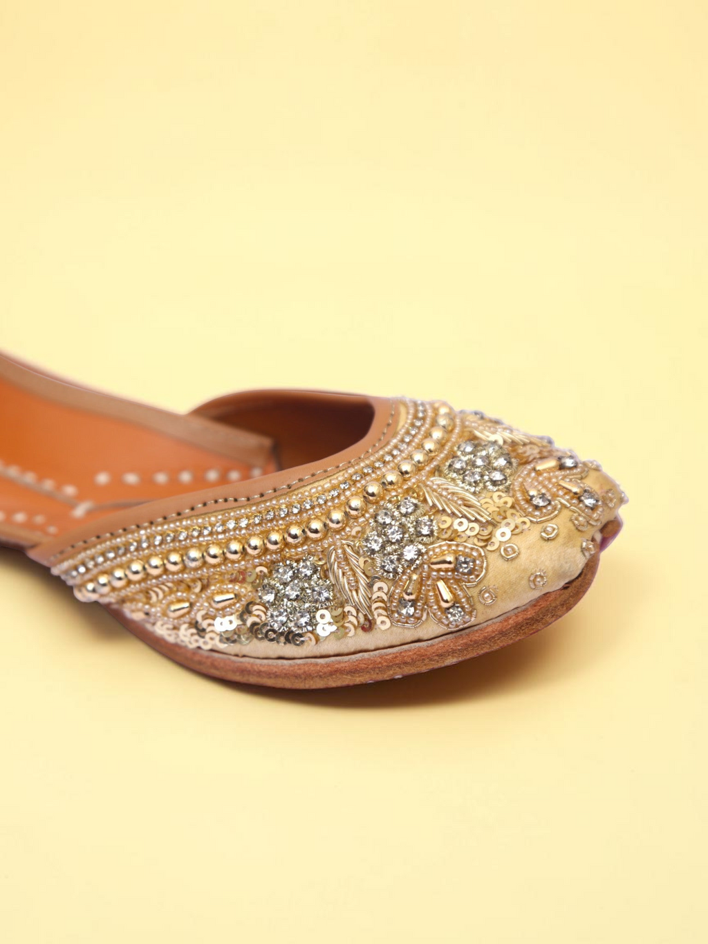 ThreadItStudio golden jutti featuring intricate pearl and sequin embroidery on a soft beige fabric background