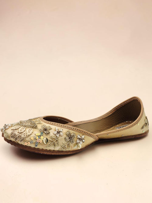 ThreadItStudio handcrafted beige jutti with intricate golden peacock embroidery and sequin detailing for festive wear.