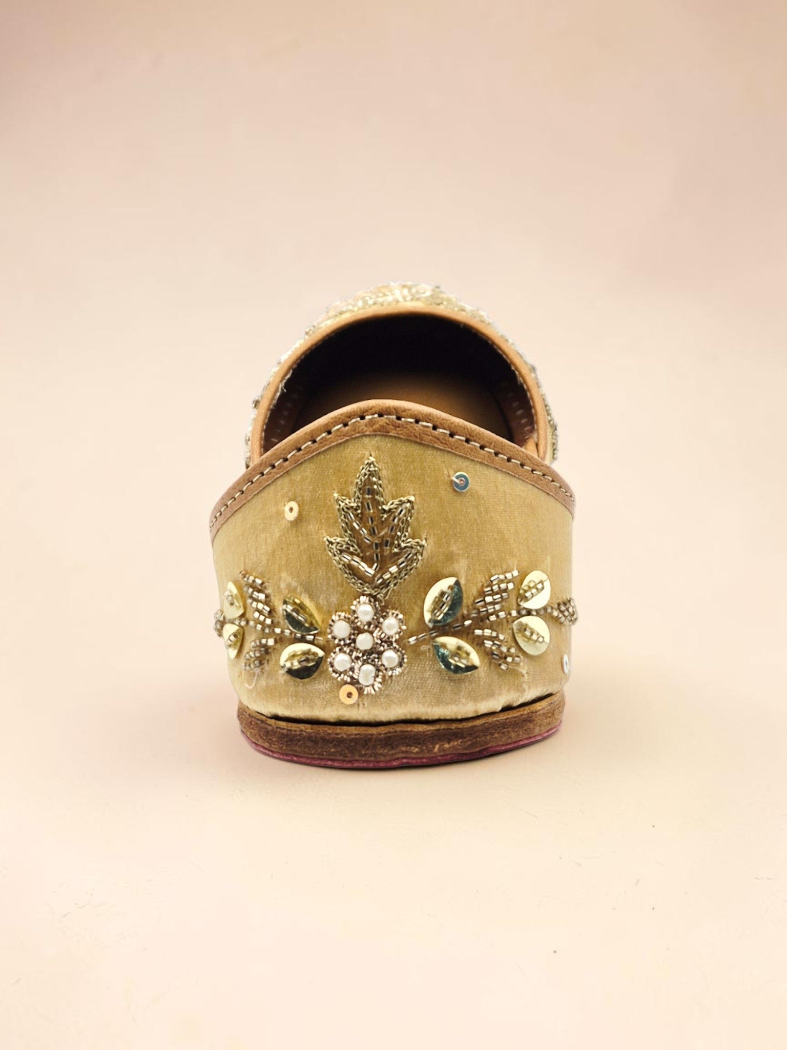 ThreadItStudio handcrafted golden jutti with intricate peacock embroidery, beads, and sequins for festive wear.