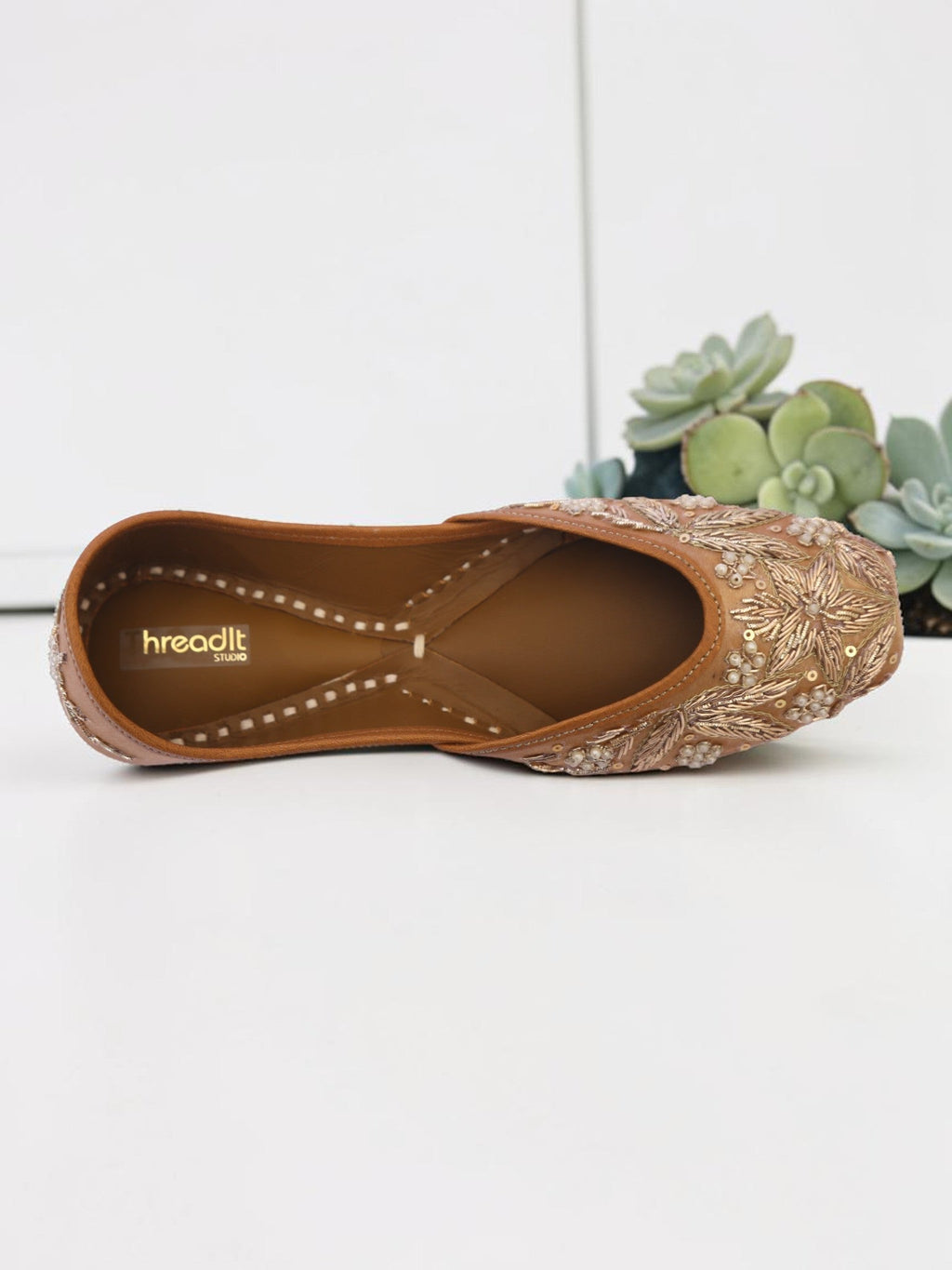 ThreadItStudio handcrafted brown jutti with intricate vintage gilt embroidery and beadwork on a white background