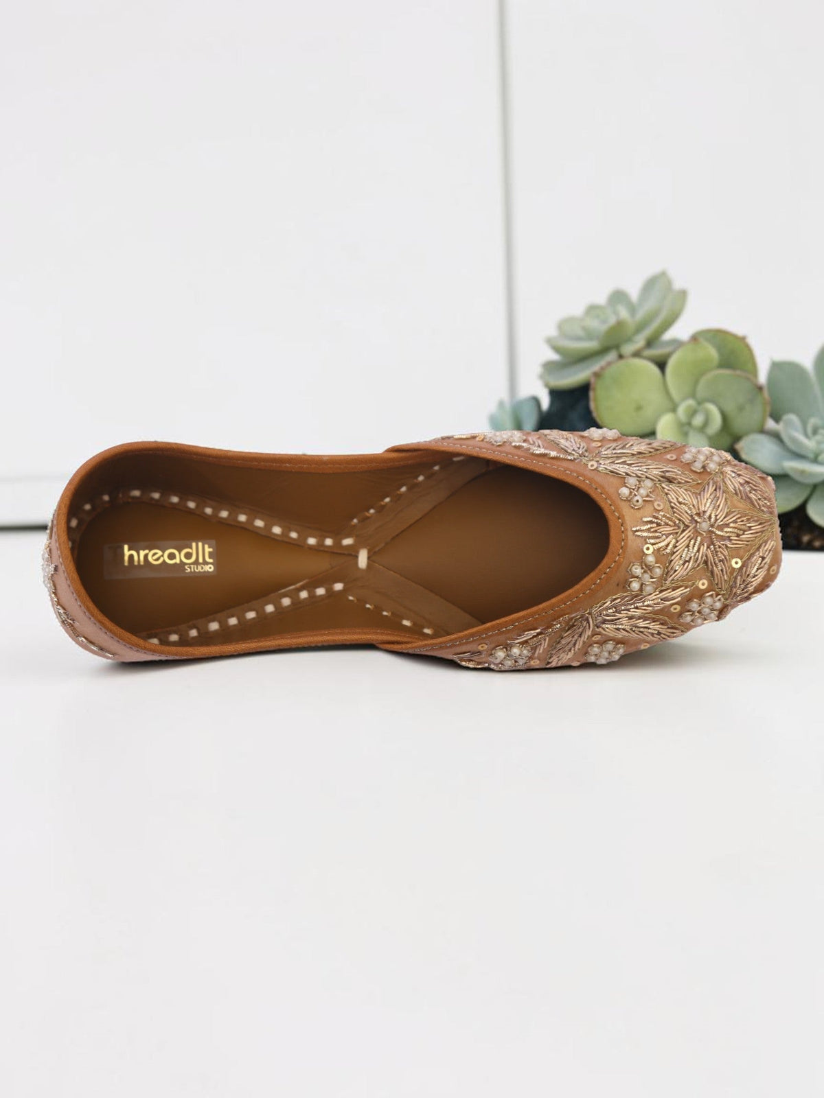 ThreadItStudio handcrafted brown jutti with intricate vintage gilt embroidery and beadwork on a white background