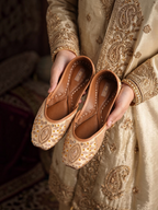 ThreadItStudio Honey Glow Steps handcrafted juttis with intricate gold embroidery and beadwork held in hands