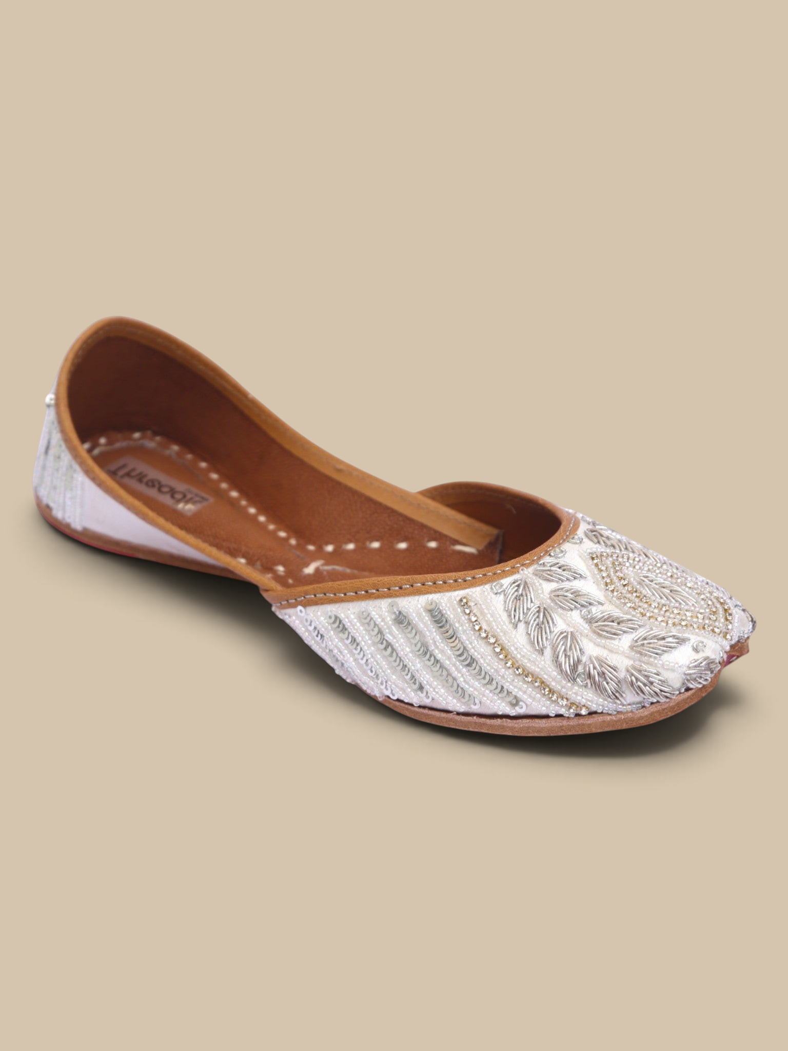 ThreadItStudio ivory juttis featuring delicate silver petal embroidery and intricate floral artisanal needlework.