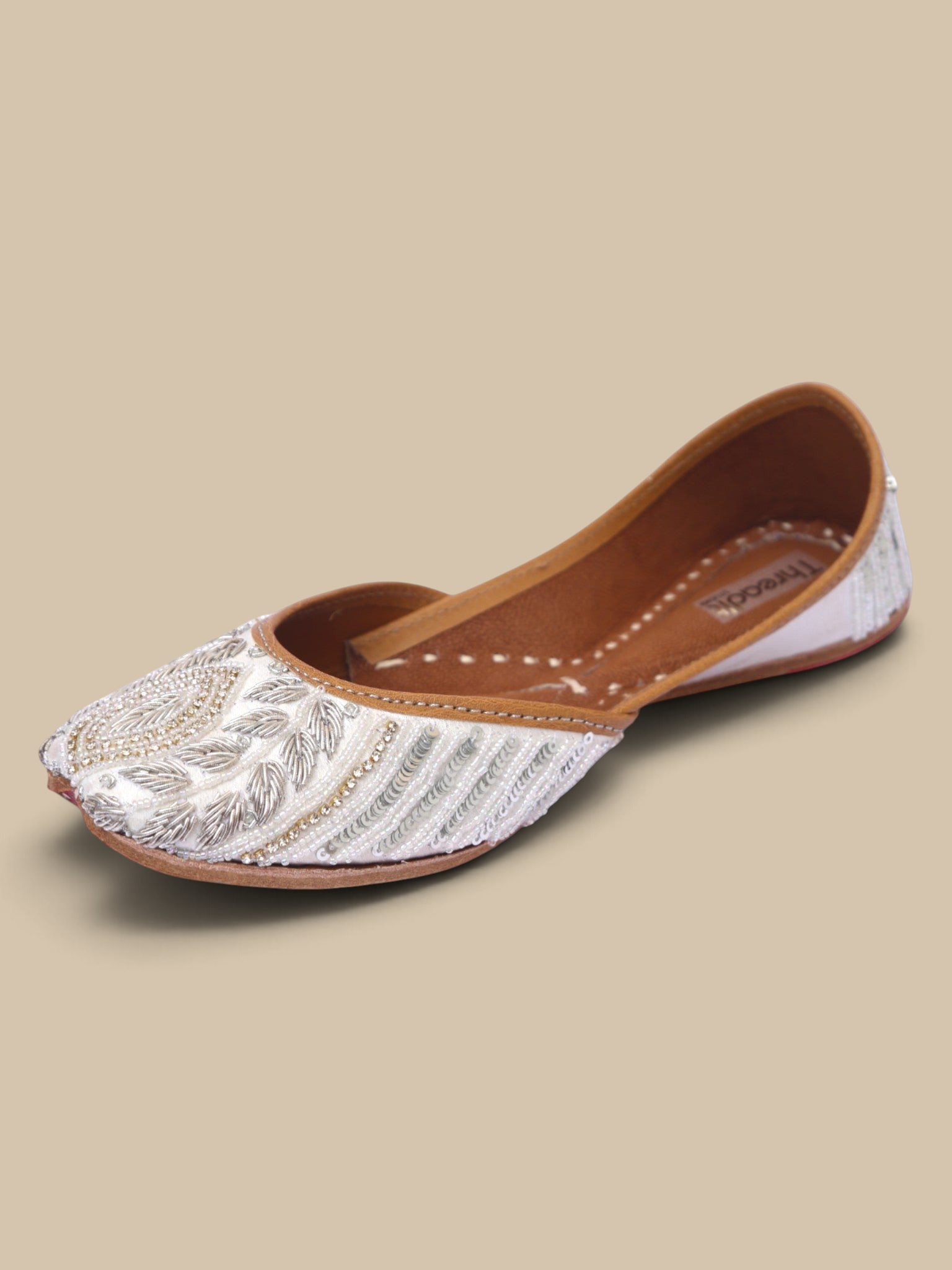 ThreadItStudio Ivory Virasat handcrafted juttis with intricate silver petal embroidery and traditional needlework.