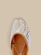 ThreadItStudio Ivory Virasat handcrafted juttis featuring intricate white petal embroidery and metallic beadwork