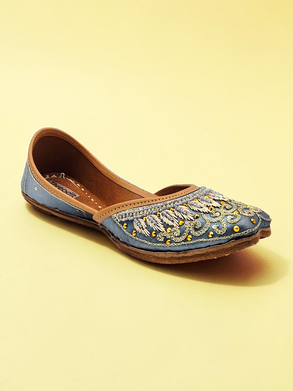 ThreadItStudio handcrafted midnight blue jutti with intricate gold eagle embroidery and traditional artisanal details.