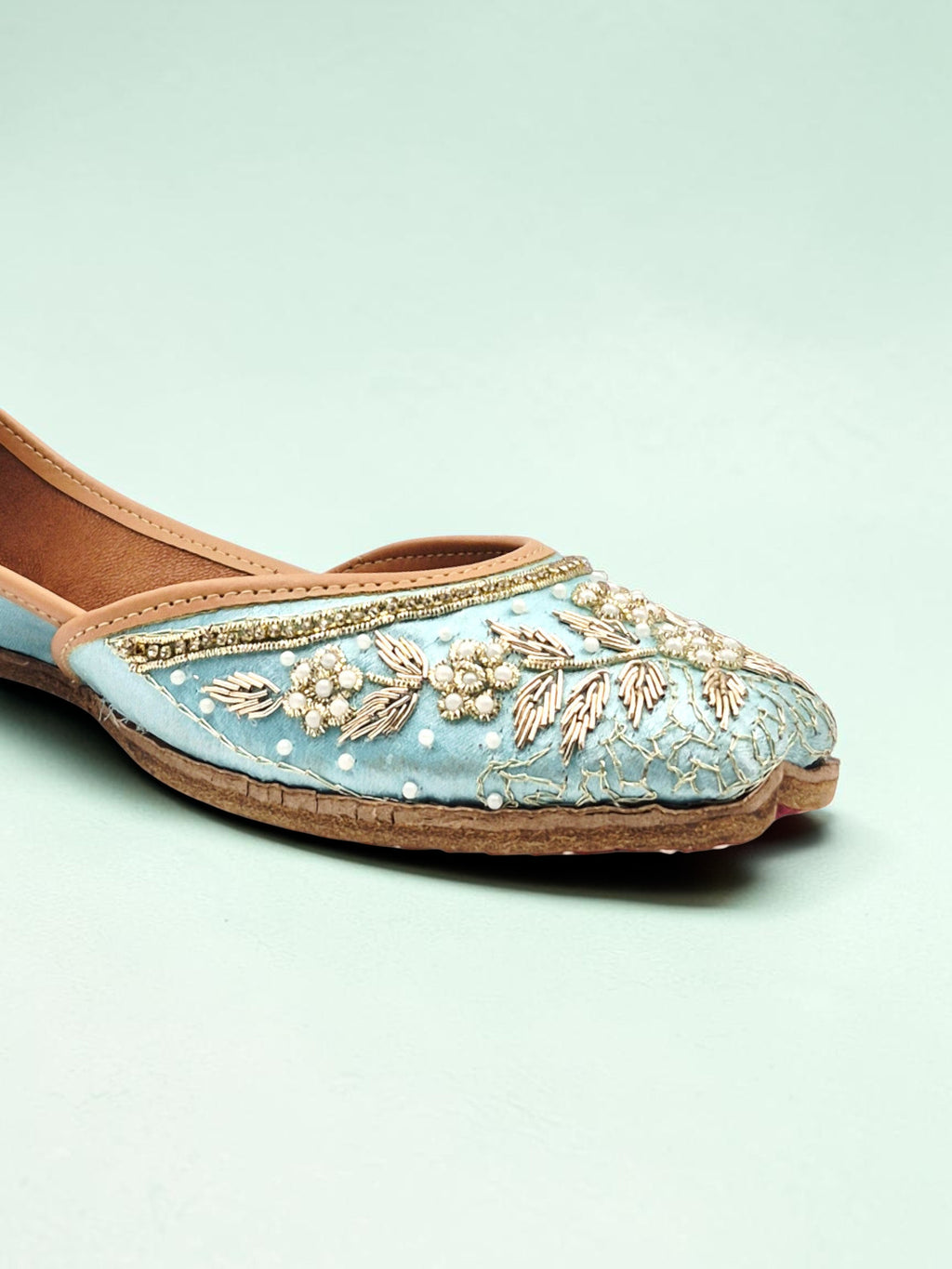 ThreadItStudio handcrafted sky blue ethnic jutti with intricate gold embroidery and pearl detailing on a soft fabric