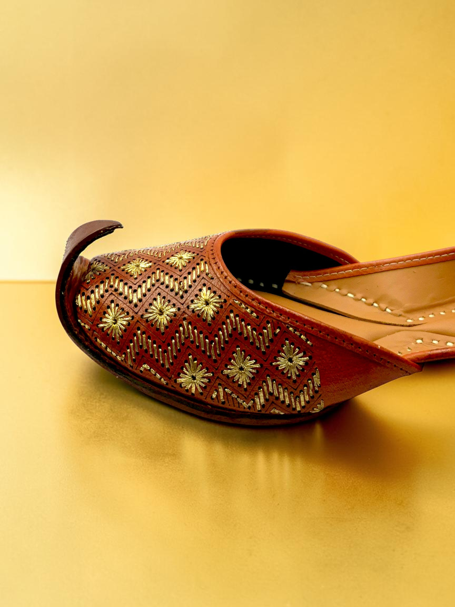 ThreadItStudio tan-brown leather jutti with gold-thread chevron embroidery and starburst floral motifs
